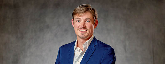A man wearing a blue suit and white shirt. Description generated by AI