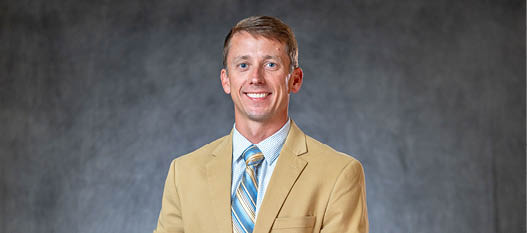 A man wearing a suit and tie is smiling for the camera. AI generated content