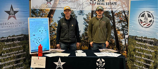 Two men are standing in front of a table with a sign that says “American Oil & Gas Association." They are posing for a picture. AI generated content