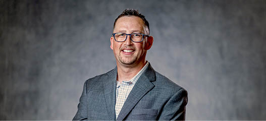 A man wearing a suit and tie is smiling for the camera. AI generated content