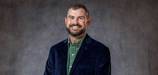 A man wearing a suit and tie is smiling for the camera. AI generated content