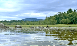 A body of water with a mountain in the background. AI generated content